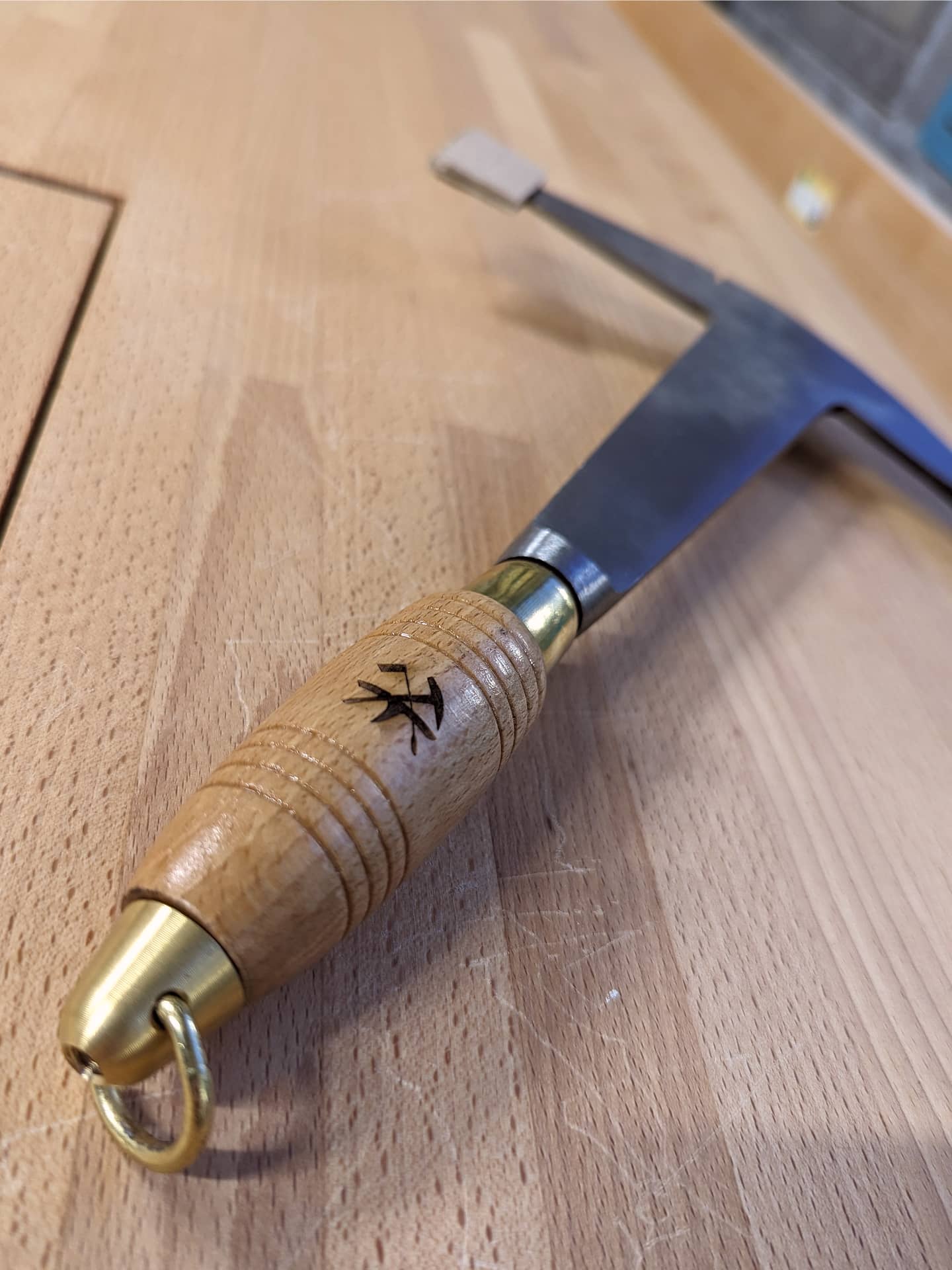 Manche d'un marteau personnalisé avec un blason de Compagnon couvreur