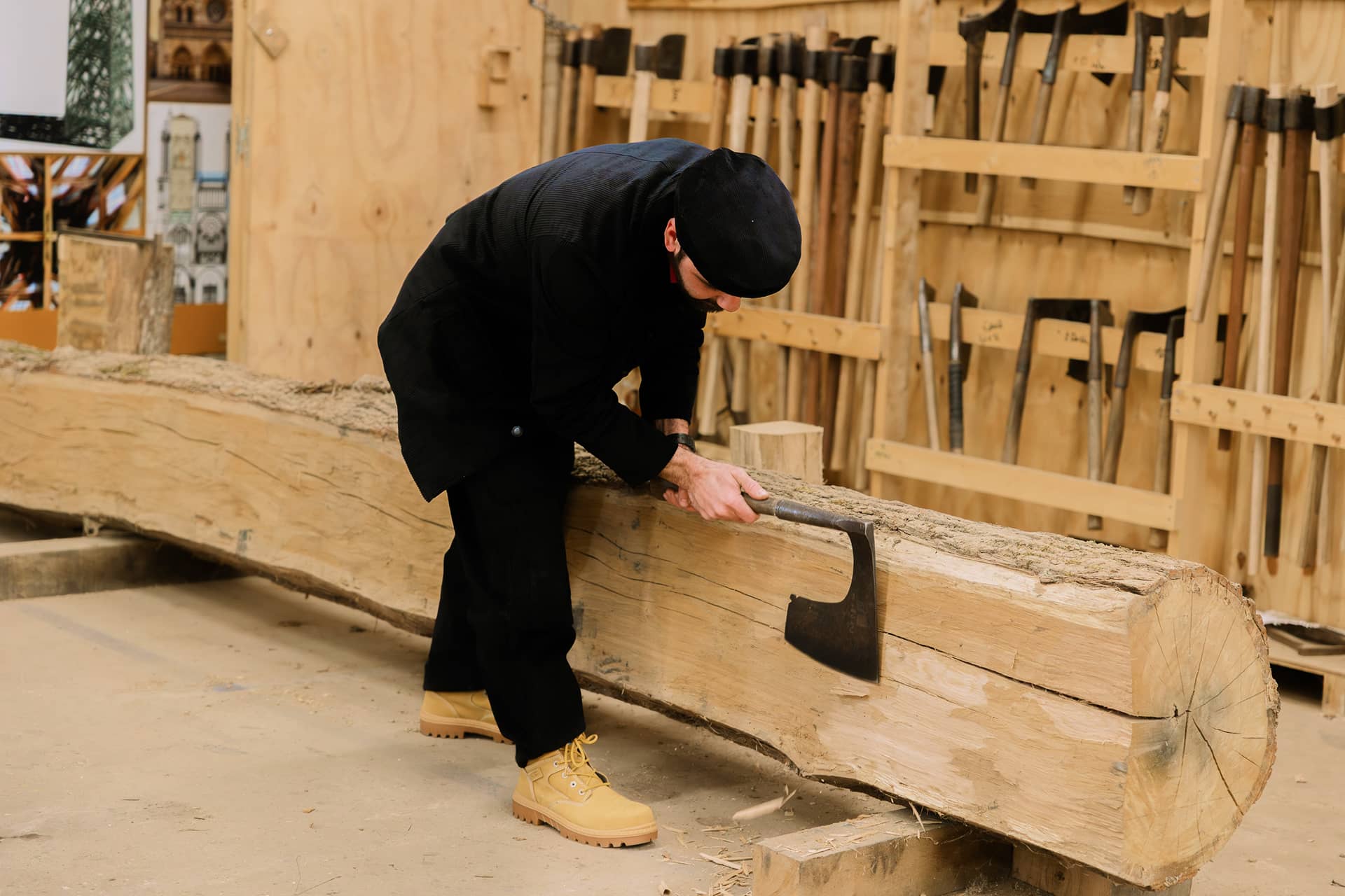 Charpentier à la hache en train d'équarrir un tronc d'arbre