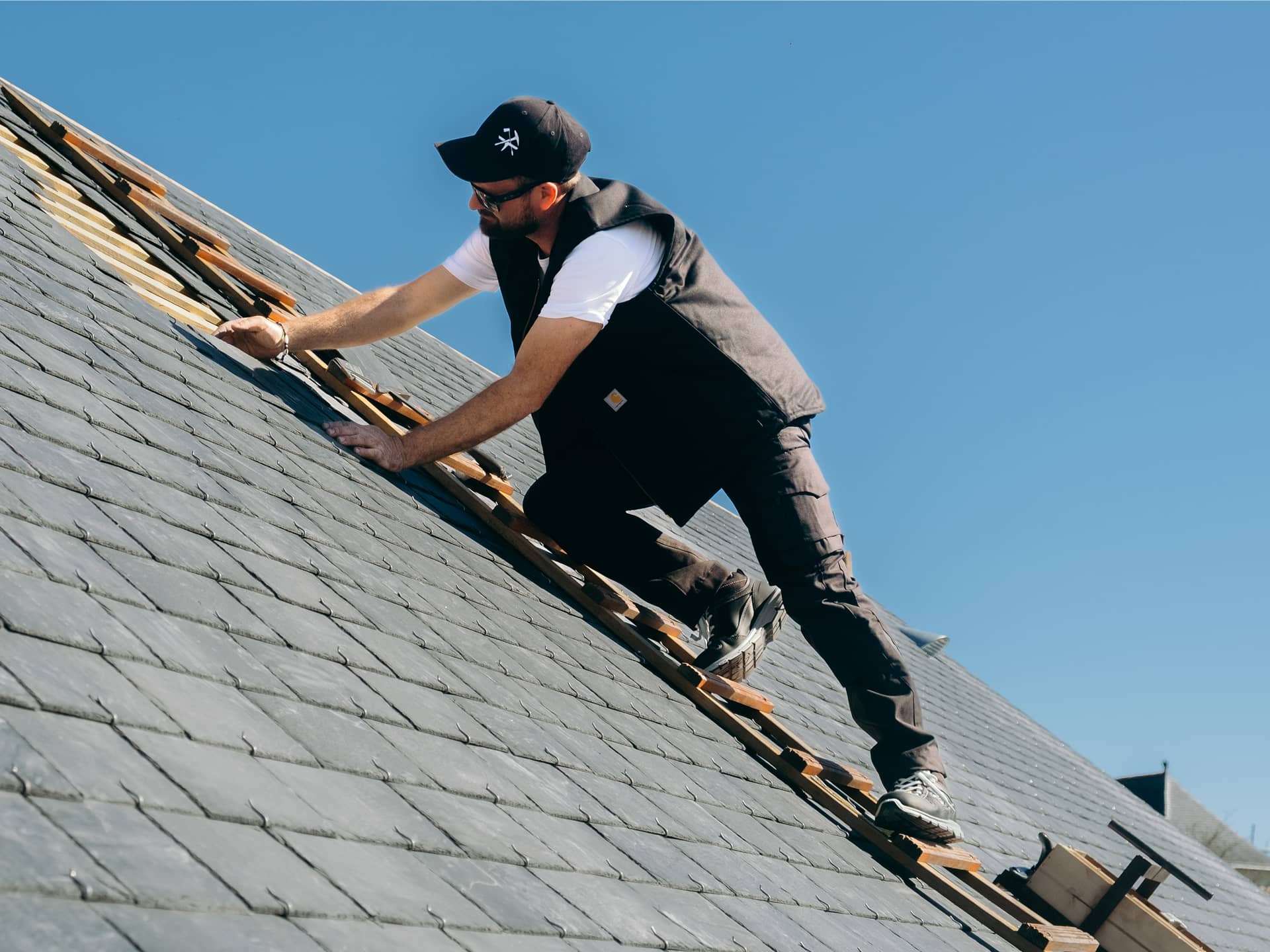 Artisnan couvreur sur un toit avec des vêtements de travail professionnels haut de gamme