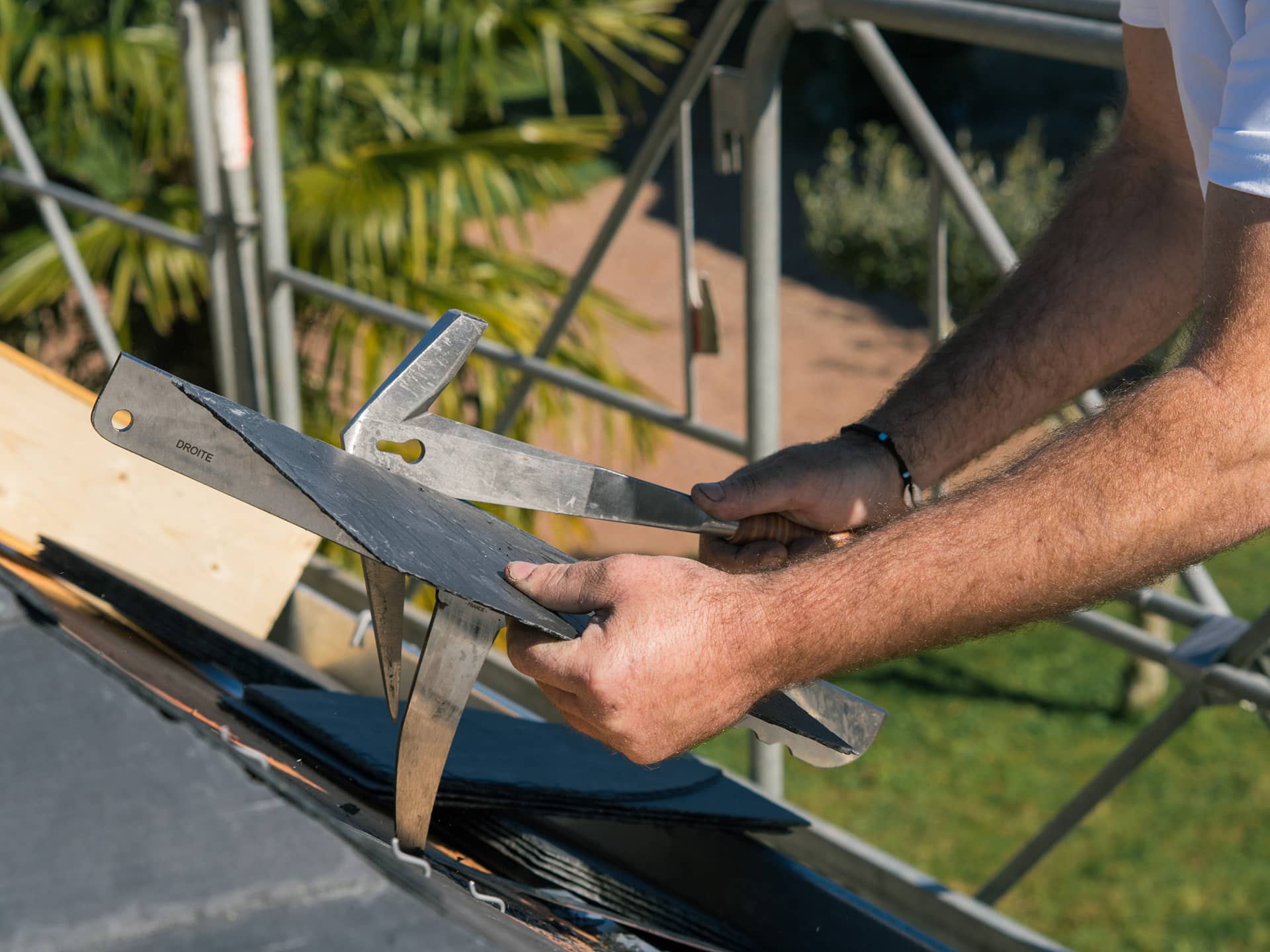 Utilisation d'une enclume de couvreur et d'un marteau de couvreur par un artisan