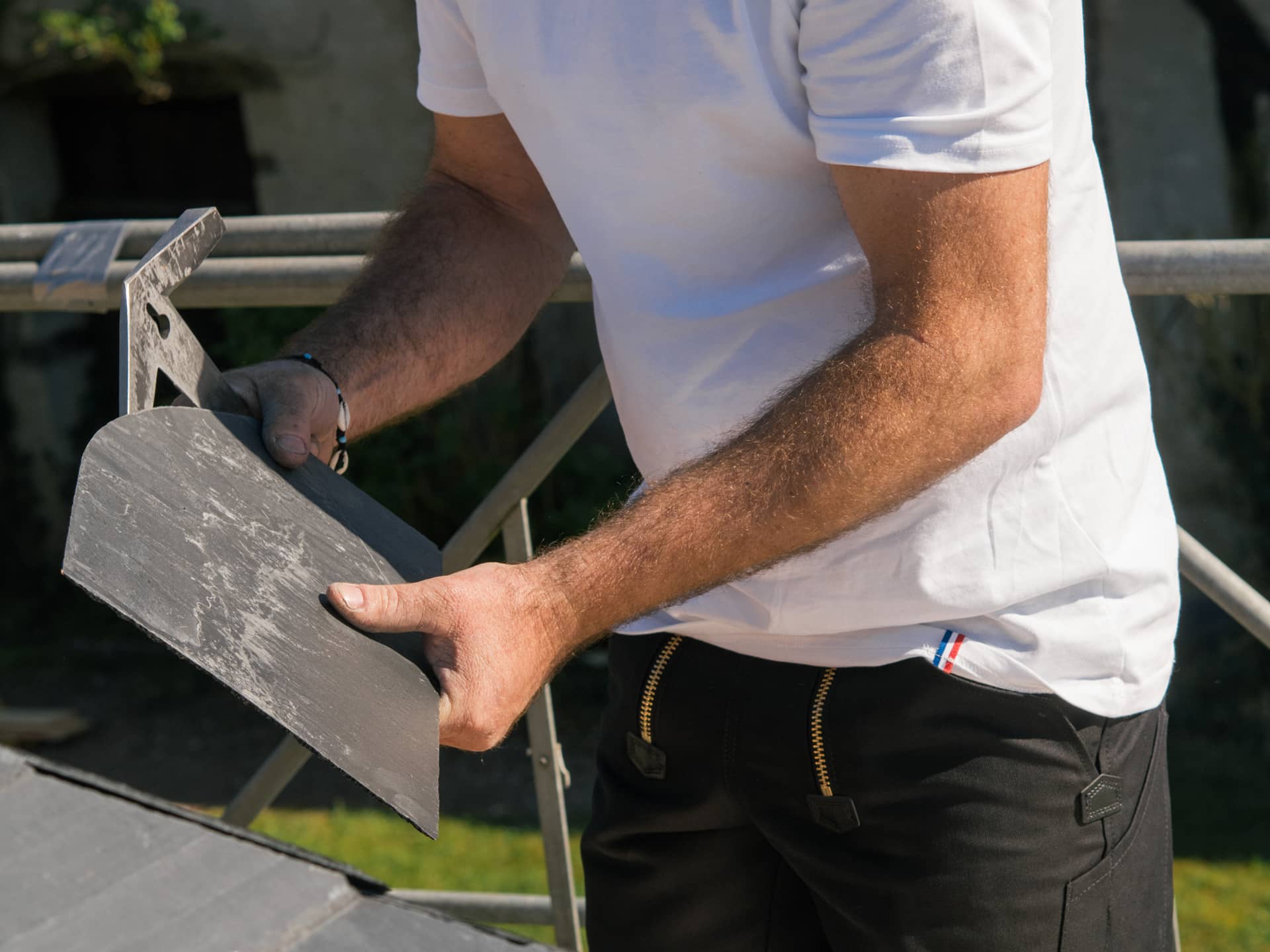 Manipultation d'un marteau de couvreur avec des ardoises