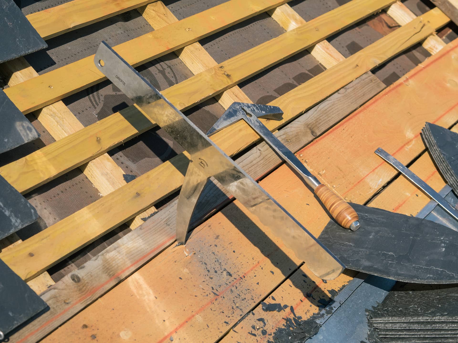 Enclume et marteau de couvreur sur un toit avec des ardoises